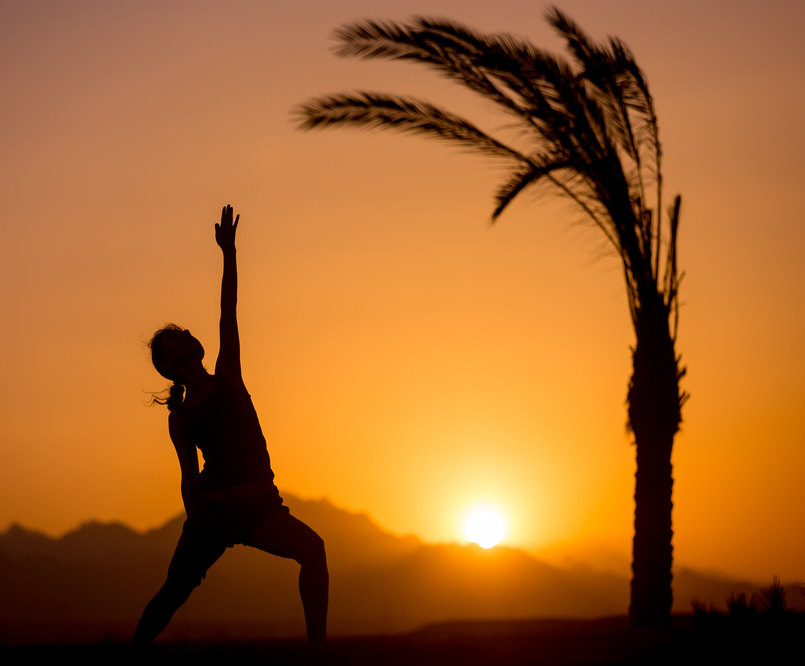 woman doing yoga during sunrise