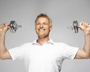 happy man lifting dumbbells to train