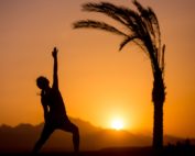 woman doing yoga at sunset